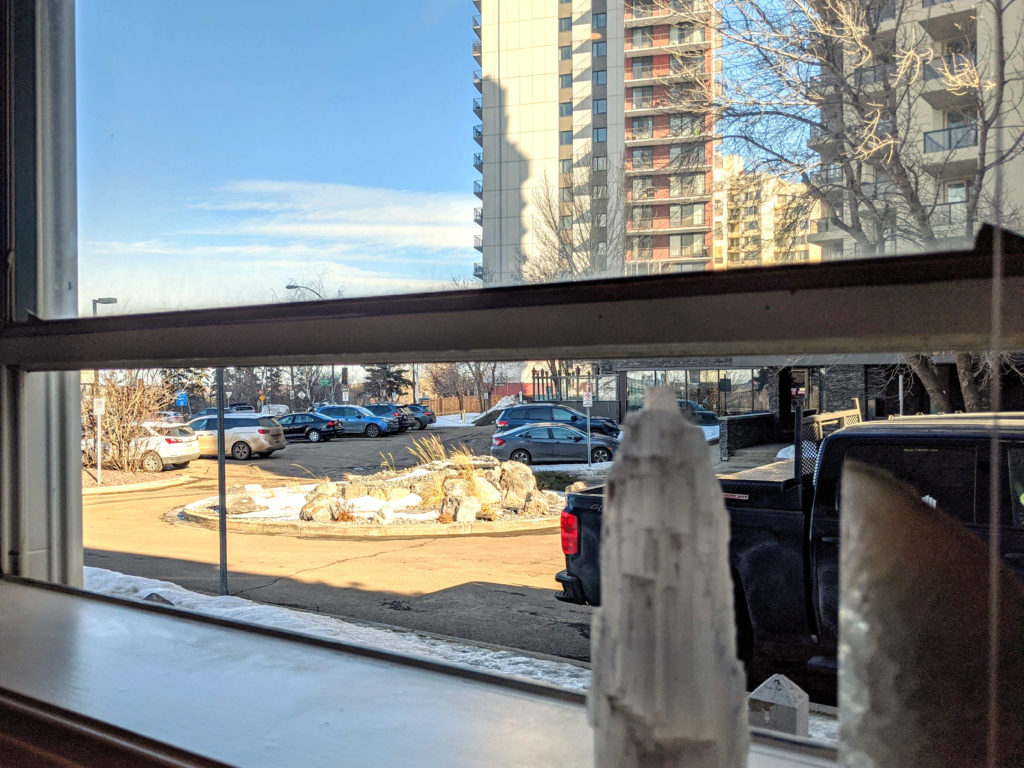 Micromeditating as self-care. A picture of a parking lot and buildings taken from a window.